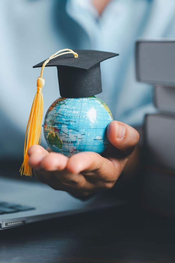 A university lecture hall with students and a large projection screen.
