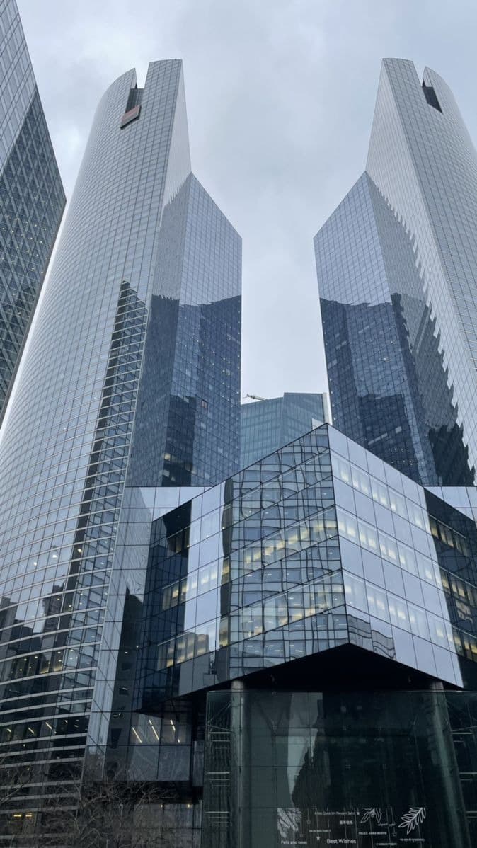 A modern corporate boardroom with a large video conference screen.